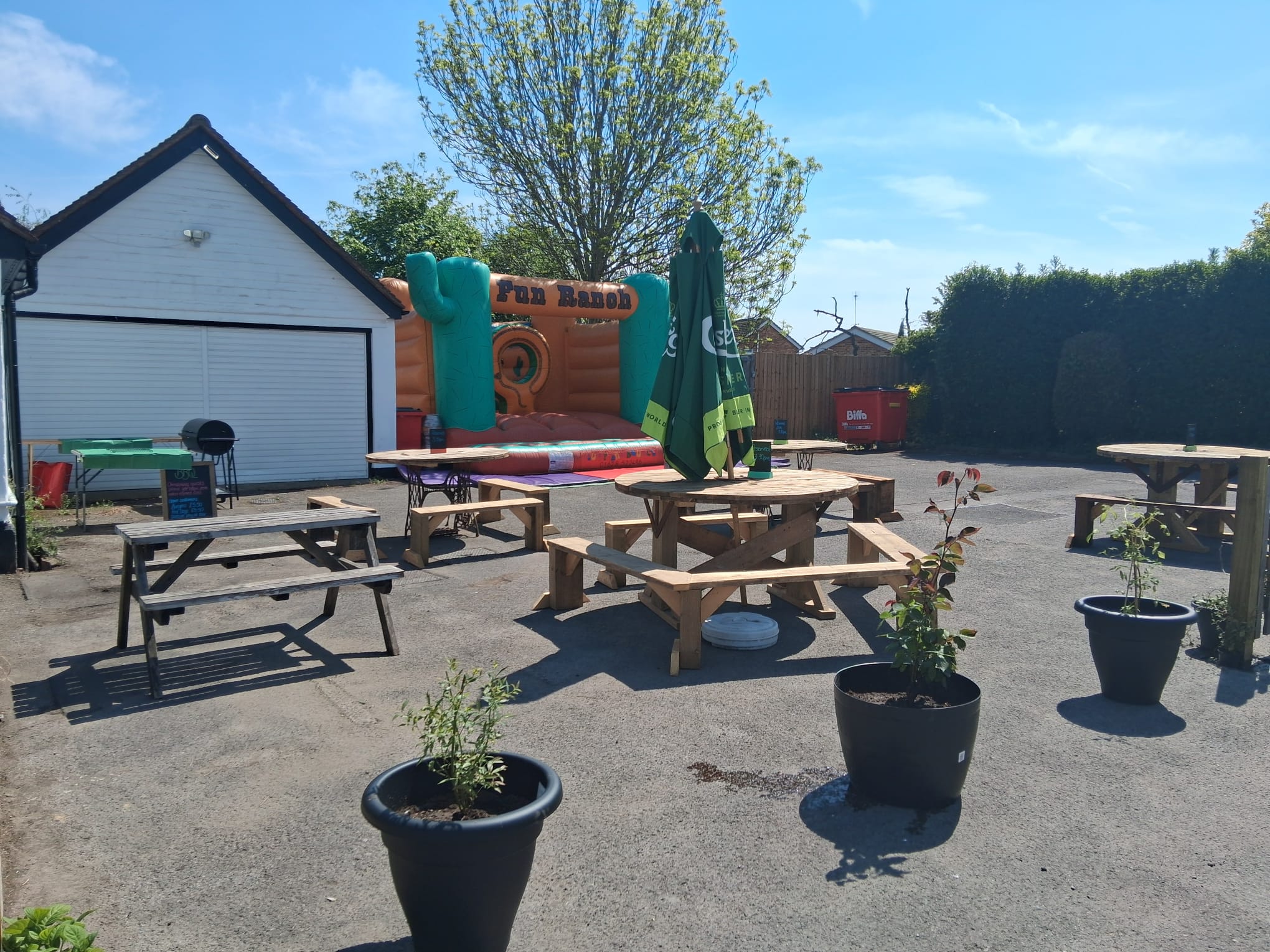 Sunny garden with picnic tables and bouncy castle