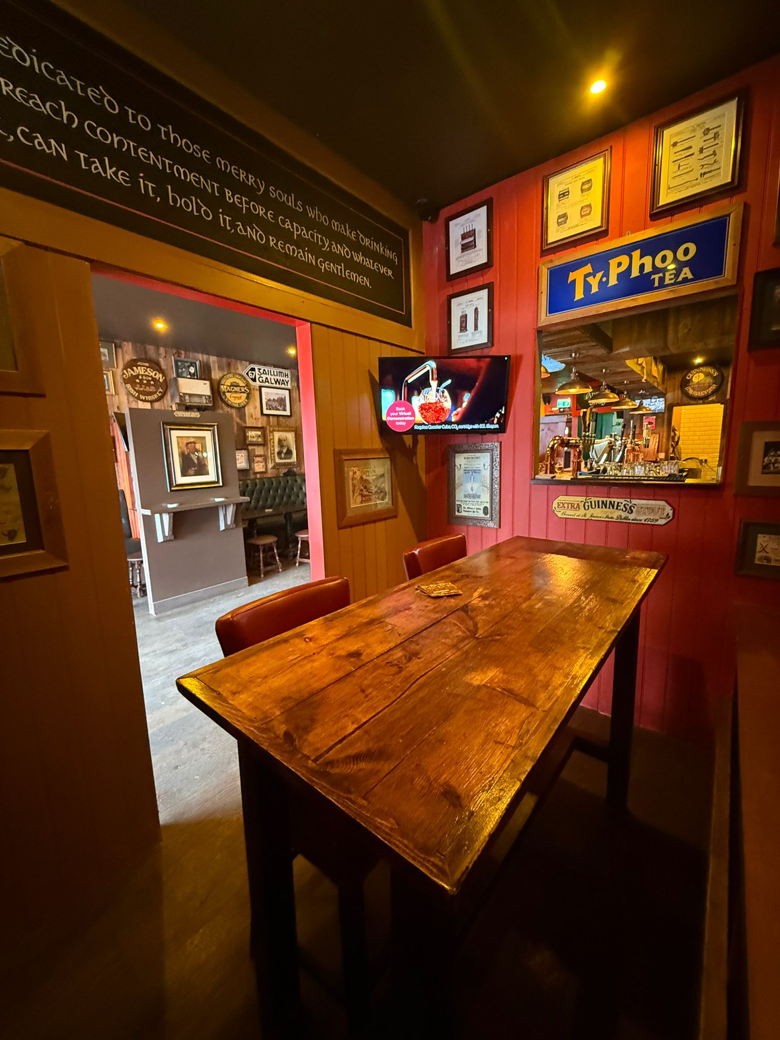 Wooden table seating beside framed Irish memorabilia